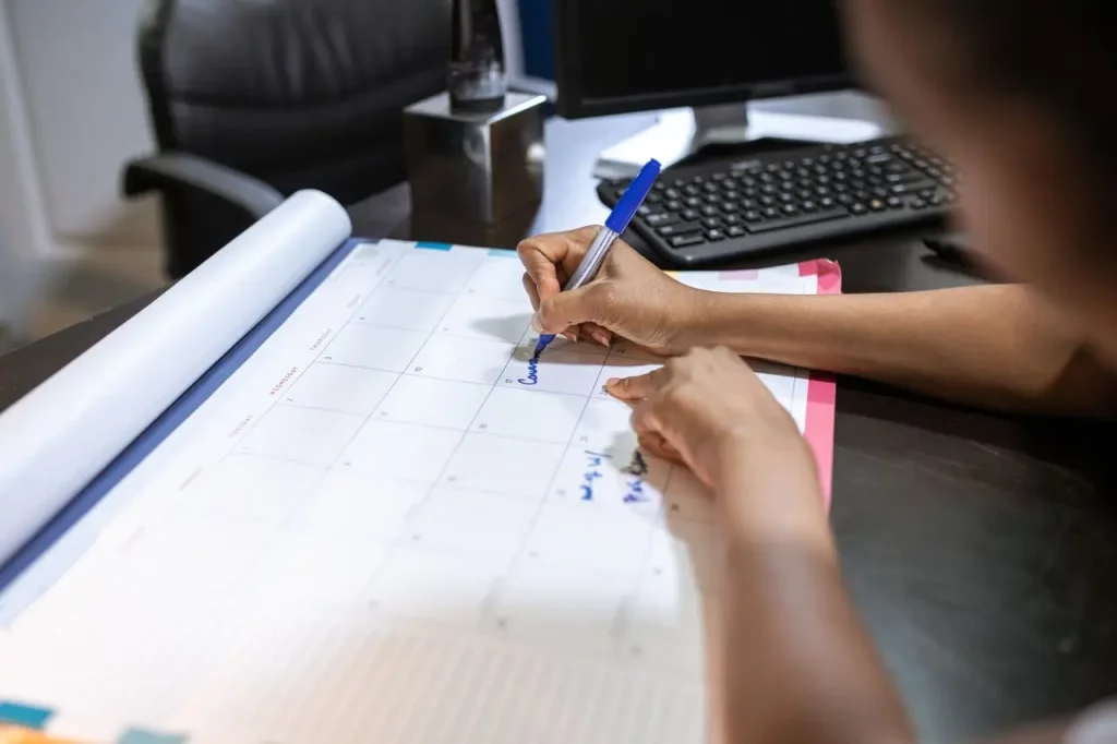 Kalender meja dan rencana jadwal di kantor, ilustrasi aplikasi manajemen cuti dan izin karyawan untuk menata saldo cuti dan shift tim